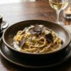 Creamy black truffle pasta served in an elegant fine dining style